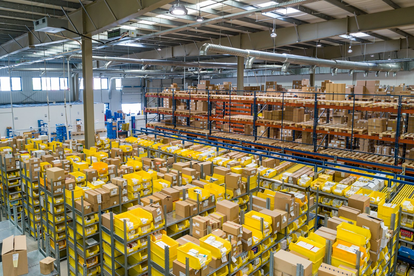 Warehouse aisles stacked with palletised and shrink-wrapped cartons ready for consolidation