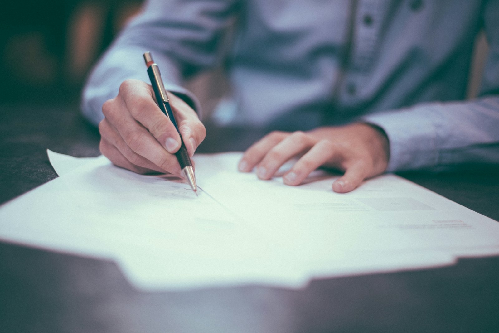 Freight agent completing shipping and customs documentation at a desk