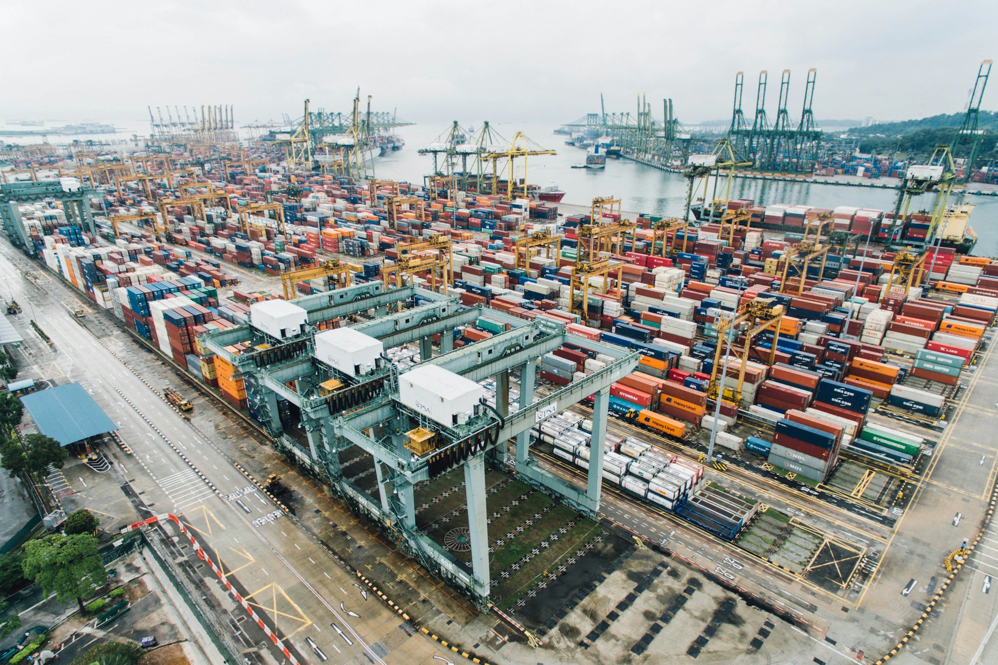 Container terminal with gantry cranes loading a vessel at dusk
